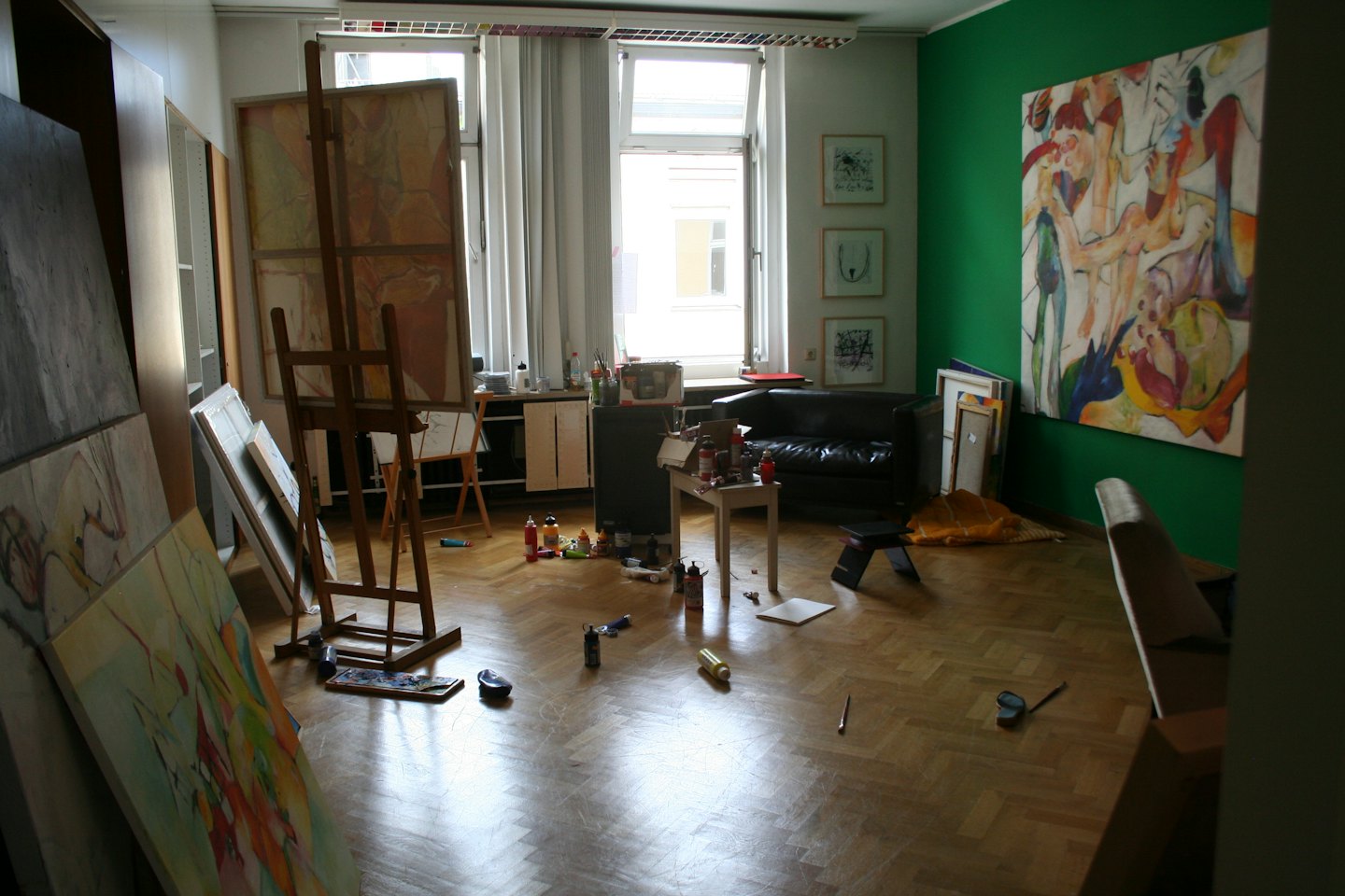 Künstleratelier mit Leinwänden, Staffeleien und Materialien.