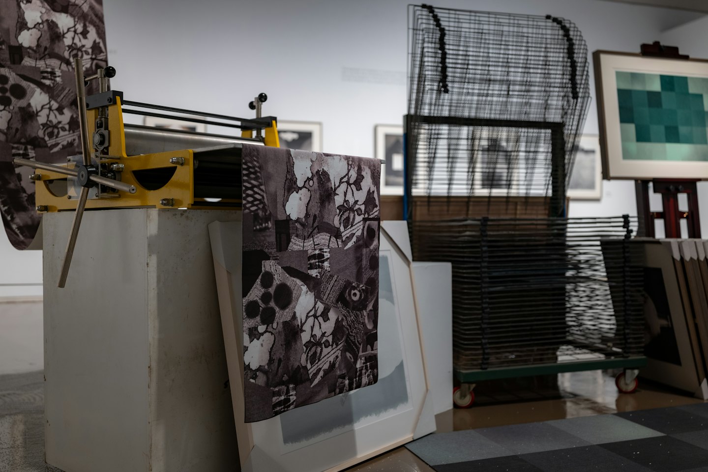 Gelbe Druckpresse mit gemustertem Stoff in einem Kunstatelier.